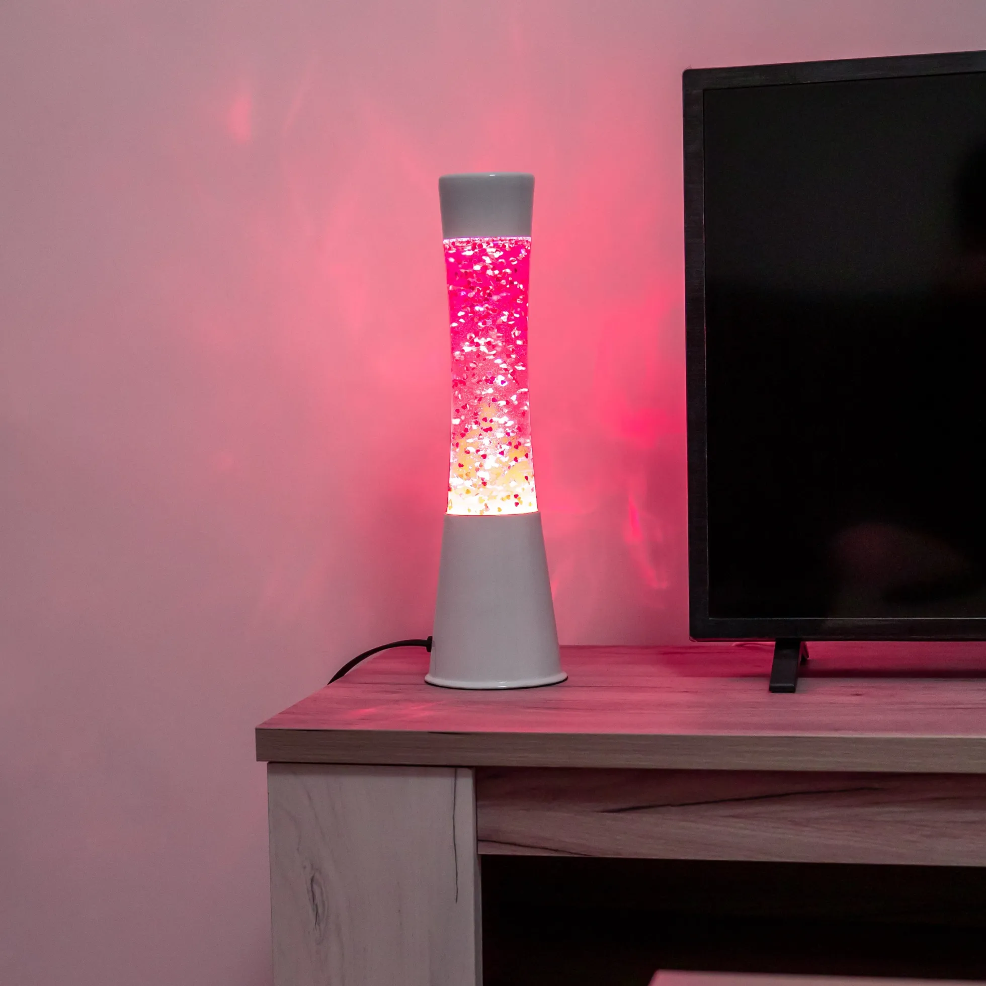 Lámpara de lava con purpurina de corazones con base blanca y líquido rosa